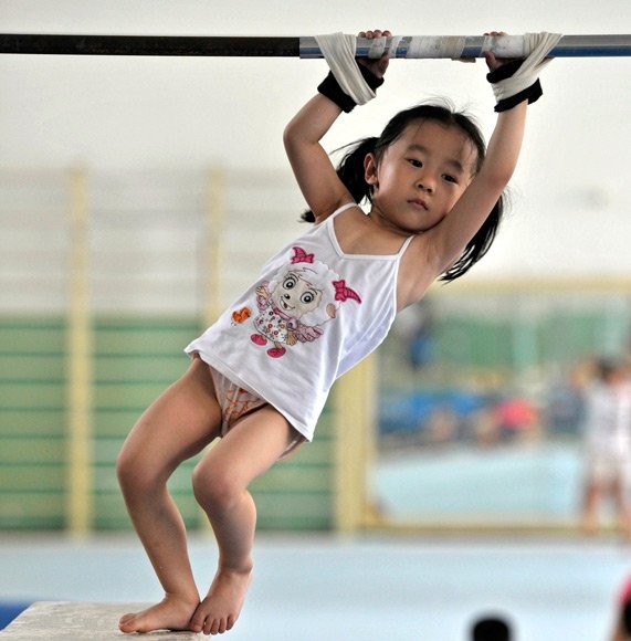 Một bé gái bị trói tay vào xà đơn...
